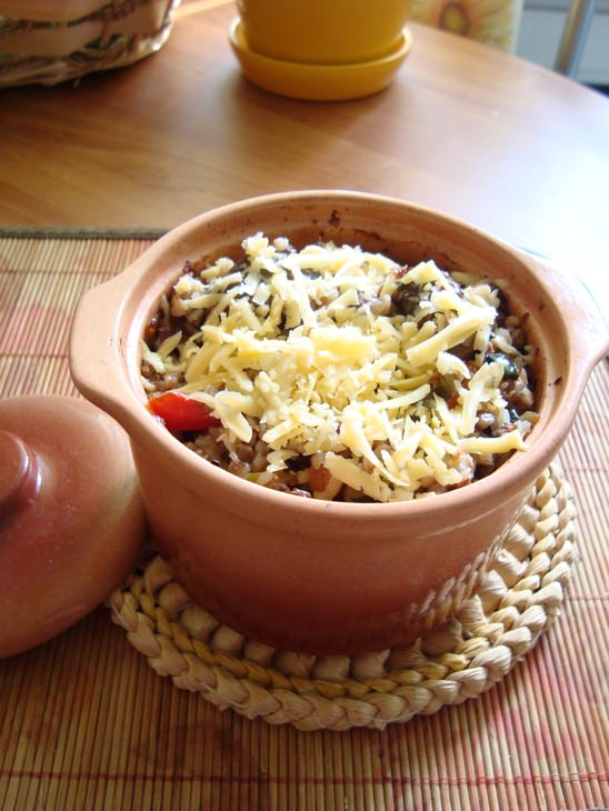 Гречневая каша из горшка с овощами и грибами под сыром.