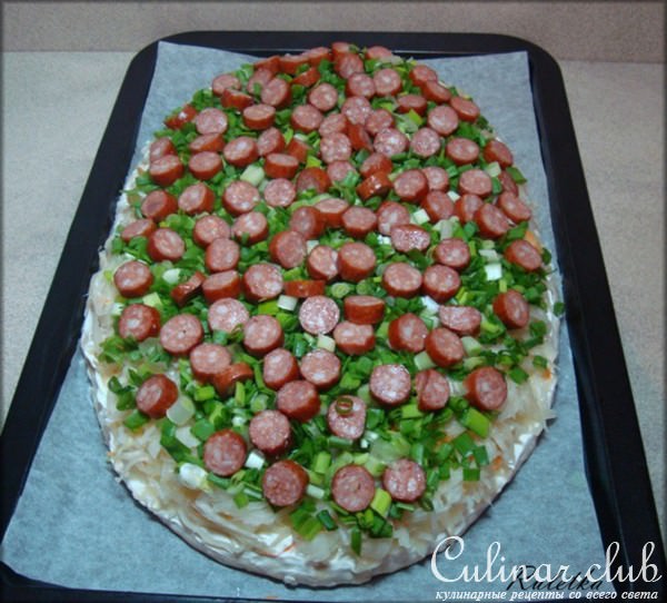 Открытый пирог из картофельного теста с копчёными колбасками и квашеной капустой.